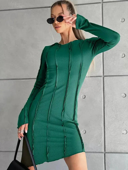 Model wearing a green long sleeve mini dress with structured seams, perfect for summer parties and events.