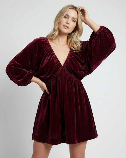 Valencia Mini Dress in burgundy velvet, featuring long sleeves and V neck silhouette by Lauven, offering elegance and comfort.