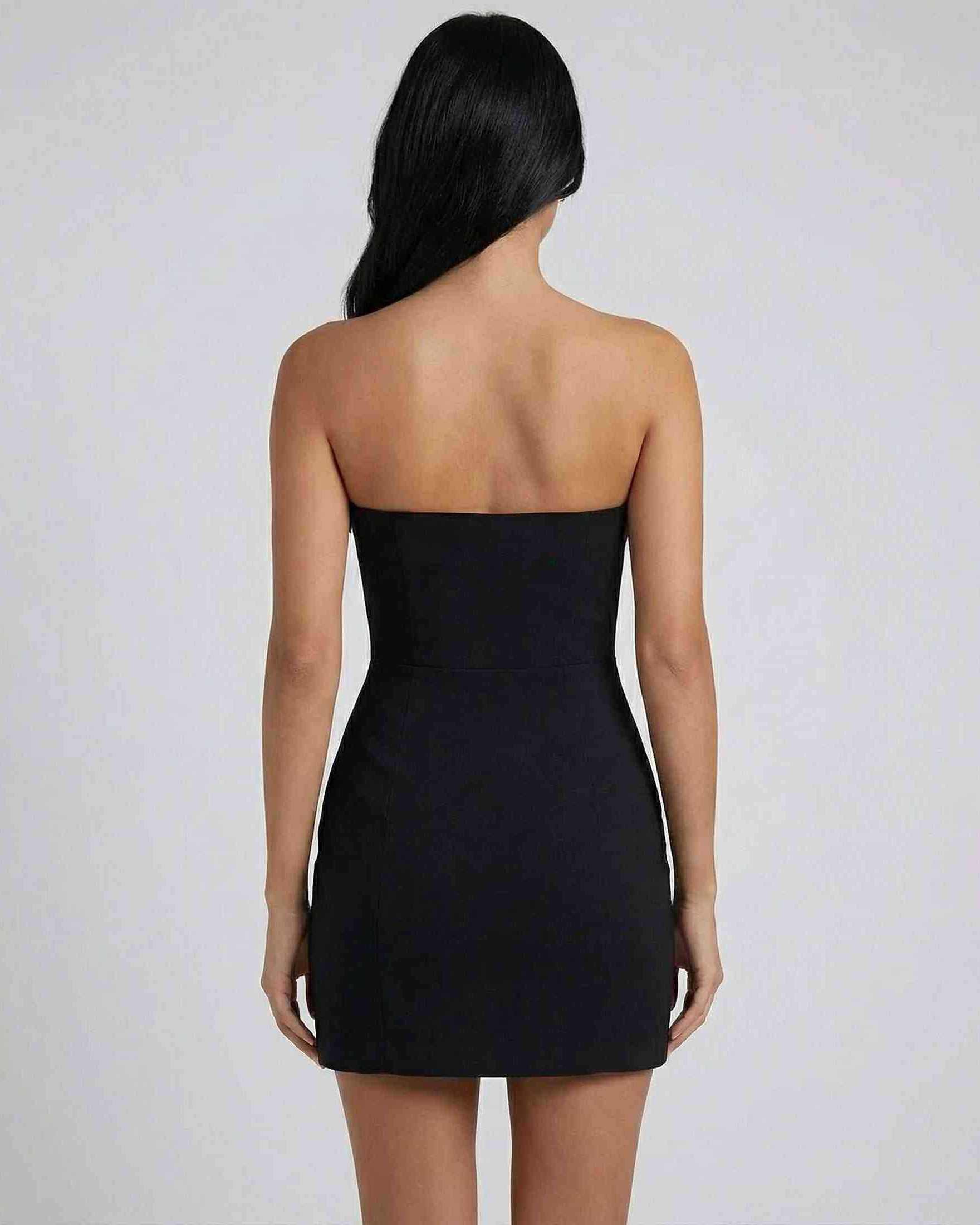 Back view of a model wearing a Lauven Valencia Mini Dress with strapless bow detail and a slim sheath silhouette.