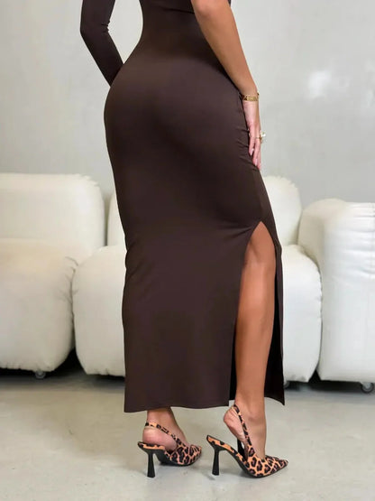 Woman showcasing the Velour Muse Maxi Dress, featuring a high side slit and elegant chocolate brown hue.