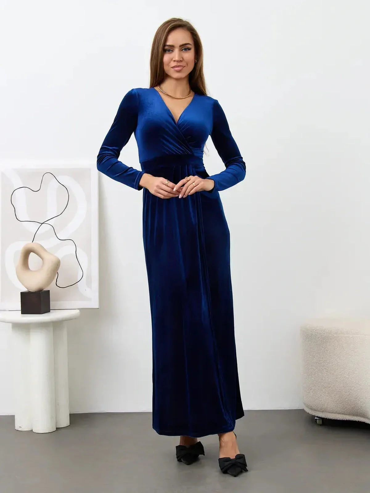Elegant woman in deep sapphire velour maxi dress with wrap bodice and V-neckline, perfect for formal occasions.