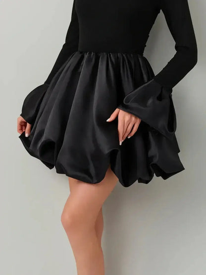Black Velvet Bloom dress featuring a soft knit bodice and a satin balloon skirt with exaggerated cuffs.
