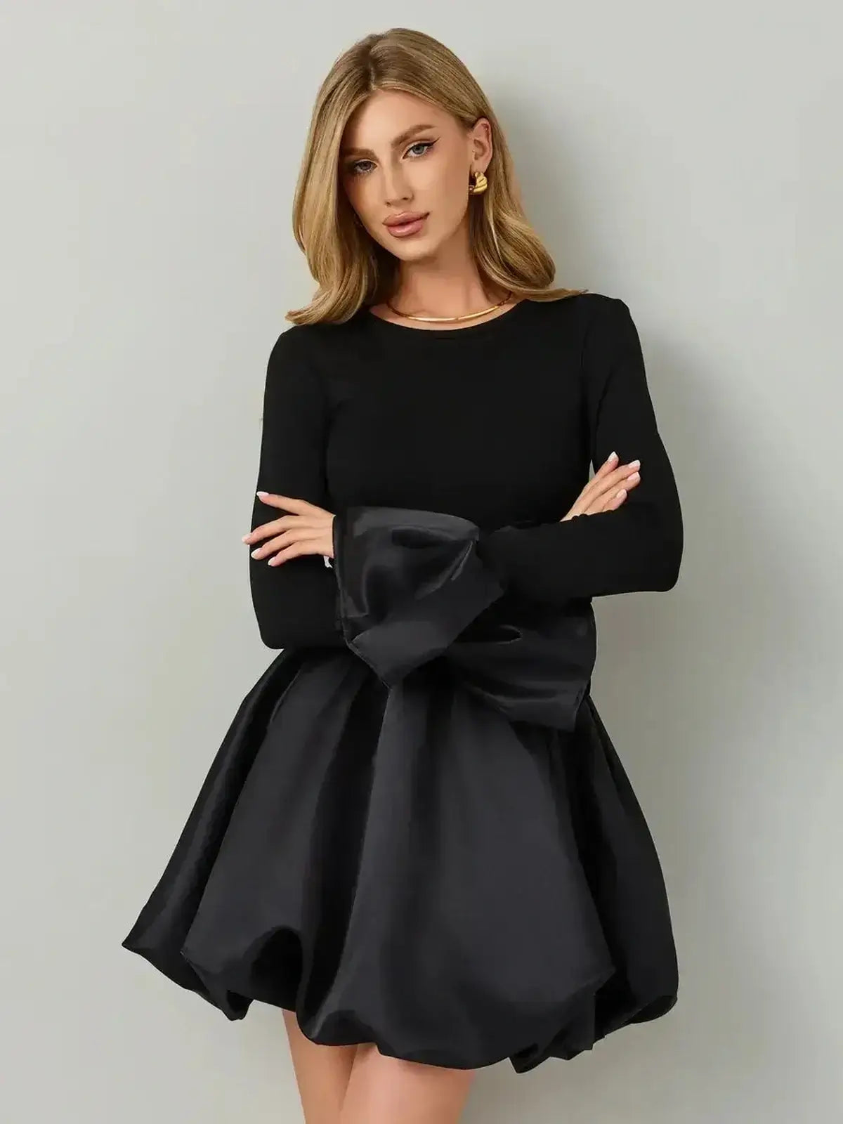 Model wearing Velvet Bloom, a black mini dress with a knit bodice and satin balloon skirt, showcasing modern elegance.