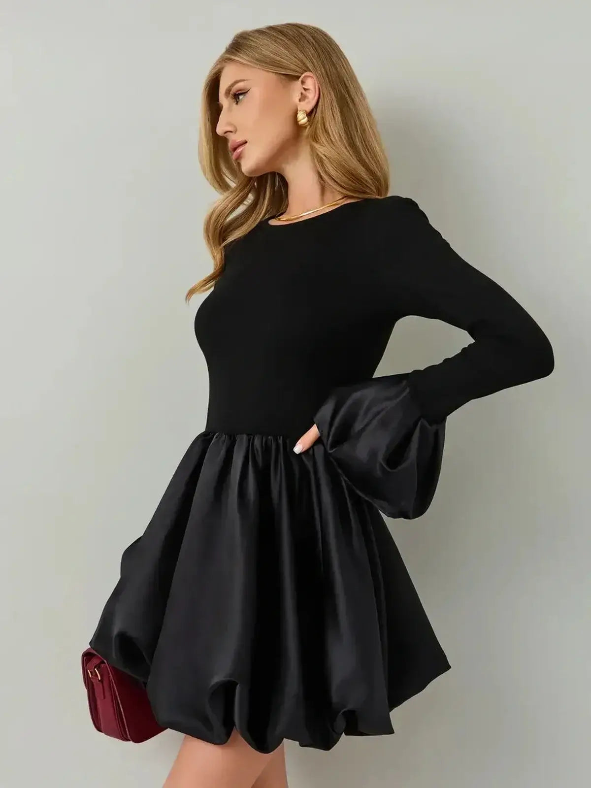 Model wearing Velvet Bloom black mini dress with a soft knit bodice and satin balloon skirt, perfect for statement occasions.