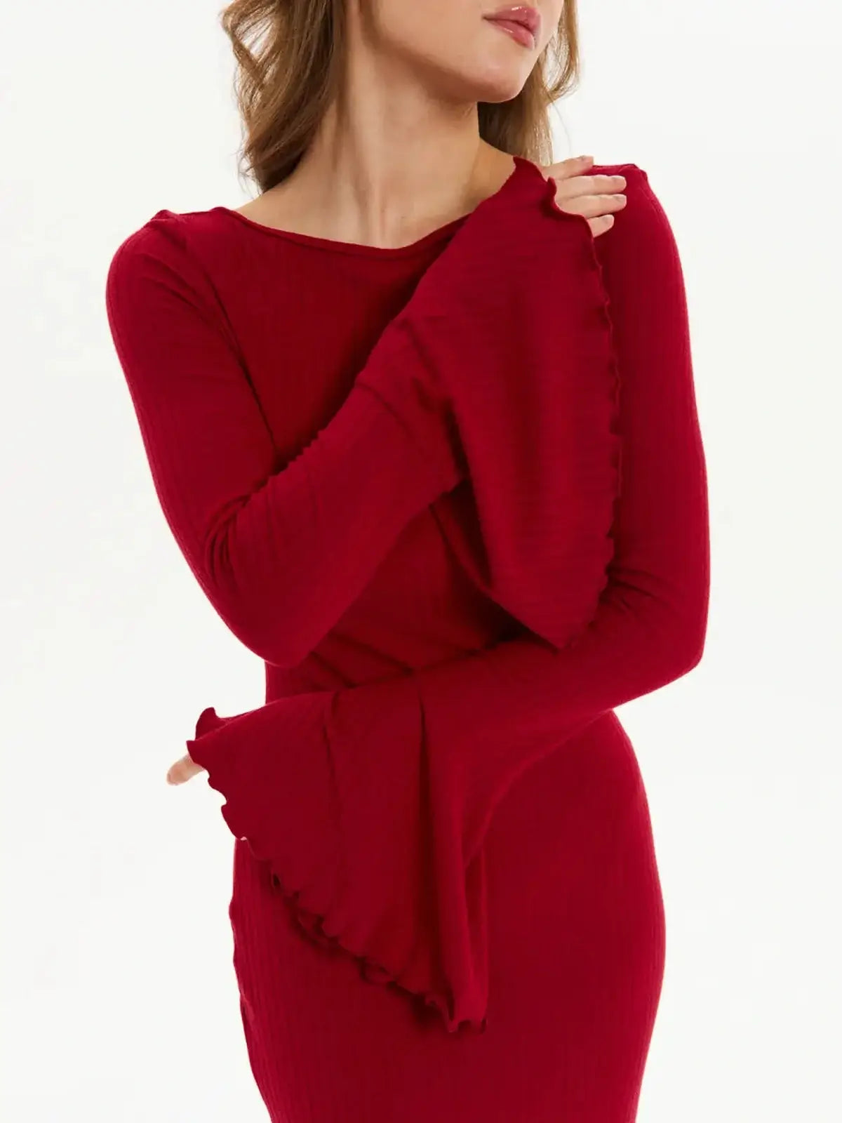 Woman wearing a red velvet flare long sleeve dress with flared cuffs, perfect for weddings and formal events.