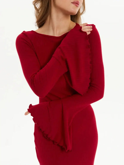 Woman wearing a red velvet flare long sleeve dress with flared cuffs, perfect for weddings and formal events.