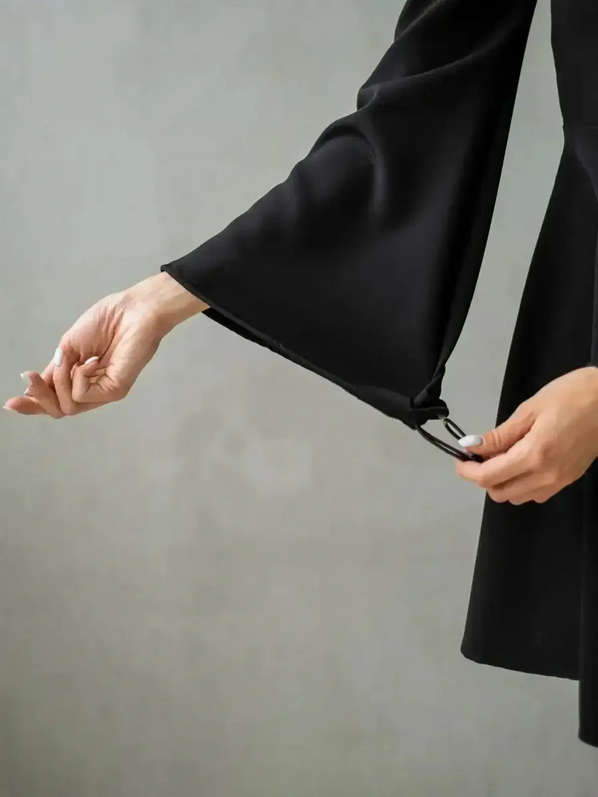 Detail of flared sleeve on the Velvet Hour black mini dress, showcasing elegant design and quality fabric.