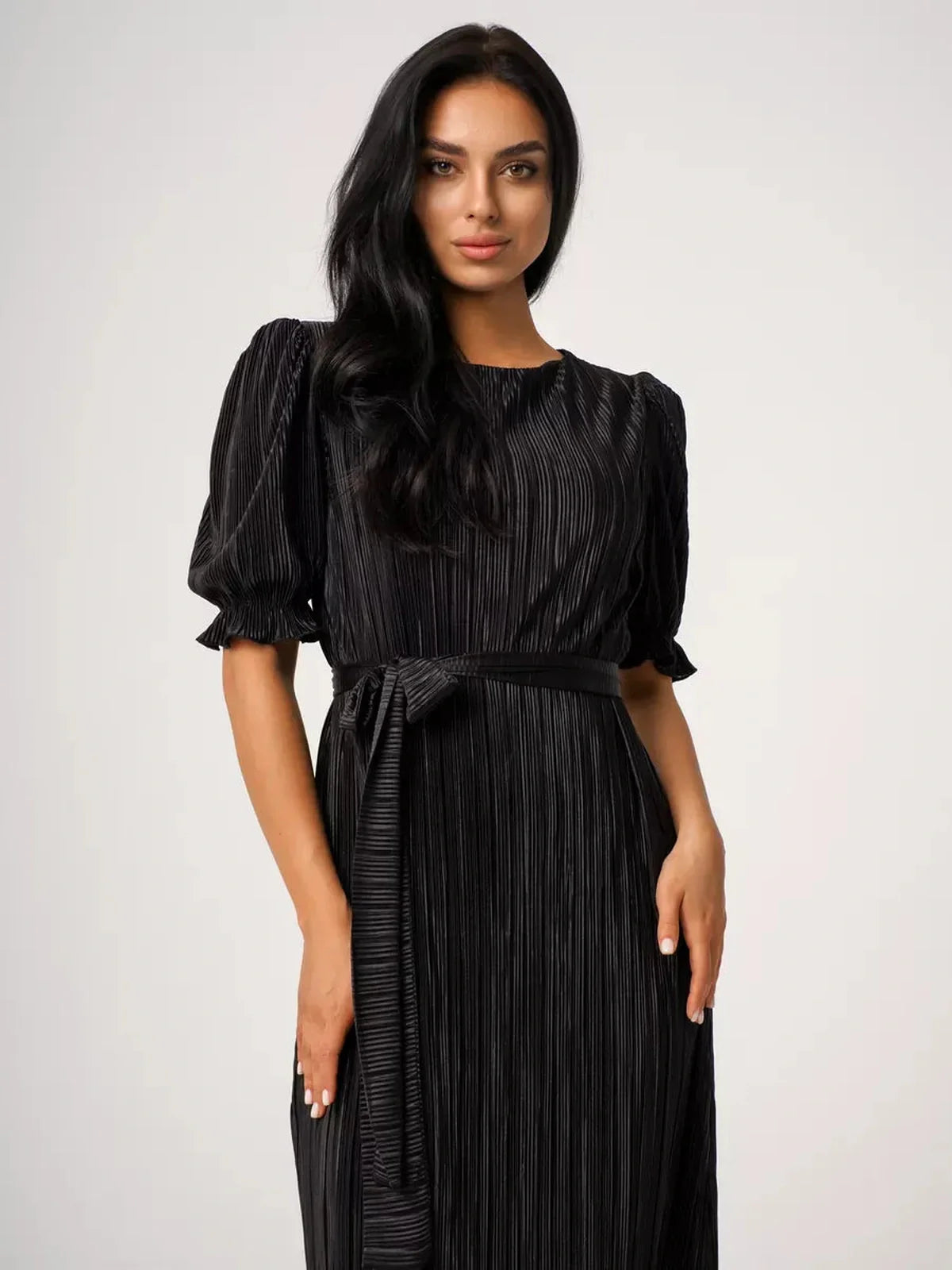 Close-up of a model wearing a Velvet Rhythm Maxi Dress with pleated texture and puff sleeves, showcasing elegance.