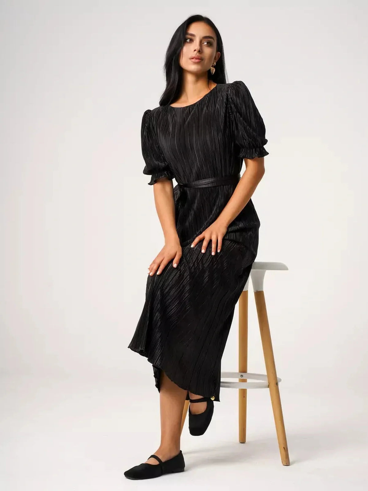 Model wearing the Velvet Rhythm Maxi Dress with puff sleeves and a sash belt, showcasing its pleated elegance.