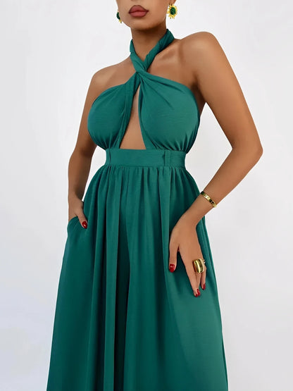 Emerald green Verona Jumpsuit featuring a halter neck, open back, and wide-leg silhouette perfect for elegant summer events.
