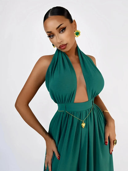 Model wearing a stylish emerald green Verona Jumpsuit with a halter neck and open back, showcasing elegant jewelry.