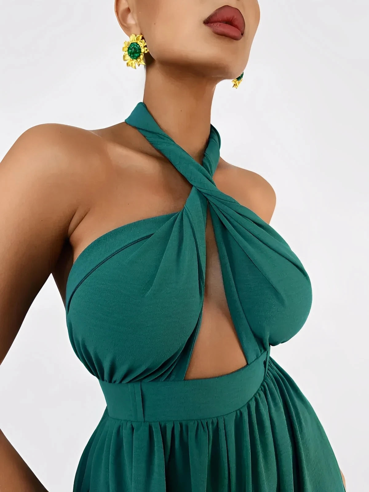 Detail of the Verona Jumpsuit featuring a twisted halter neckline and elegant emerald fabric.
