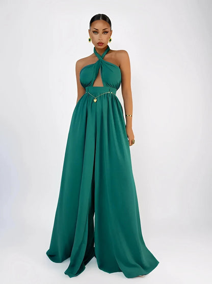 Model wearing an emerald green Verona Jumpsuit featuring halter neck, open back, and wide leg design.