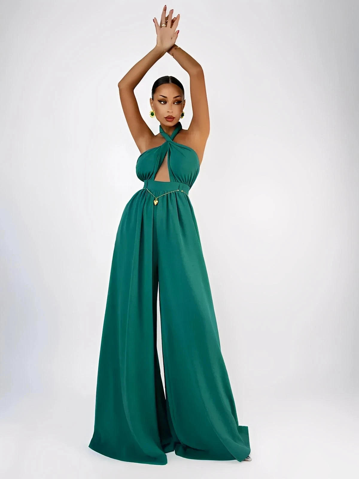 Model showcasing the Verona Jumpsuit in emerald, featuring a halter neck, open back, and wide legs for elegant silhouettes.