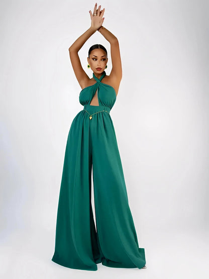 Model showcasing the Verona Jumpsuit in emerald, featuring a halter neck, open back, and wide legs for elegant silhouettes.