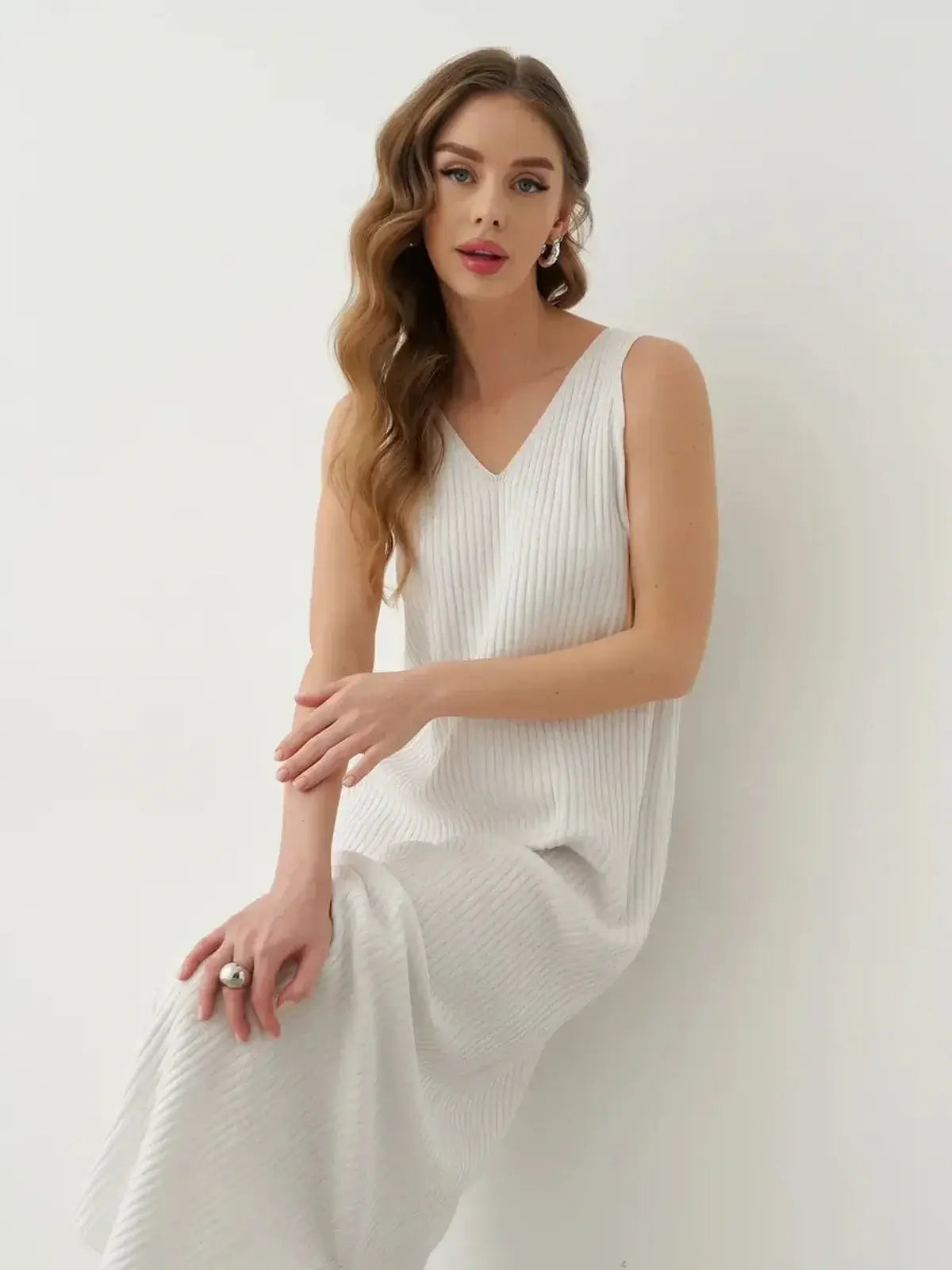 Model wearing the Verona Maxi Dress, a white ribbed cotton-acrylic knit, showcasing elegance and summer style.