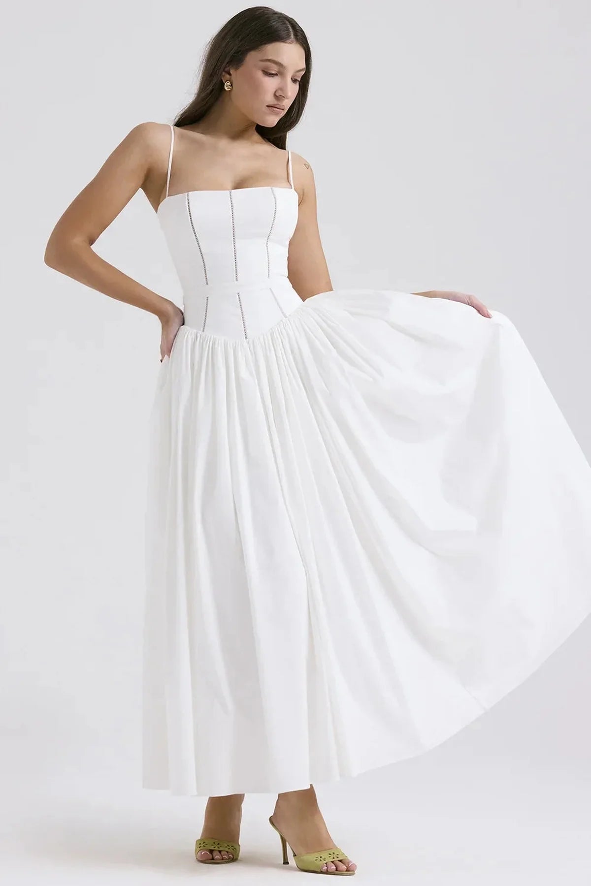 Elegant white maxi dress with a flowing silhouette and delicate spaghetti straps, ideal for wedding guests or summer occasions.