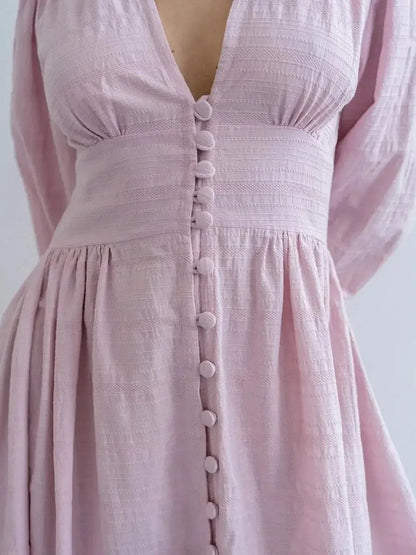 Close-up of the Willow Grace Maxi Dress in soft pink with a plunging V-neckline and textured button-front closure.