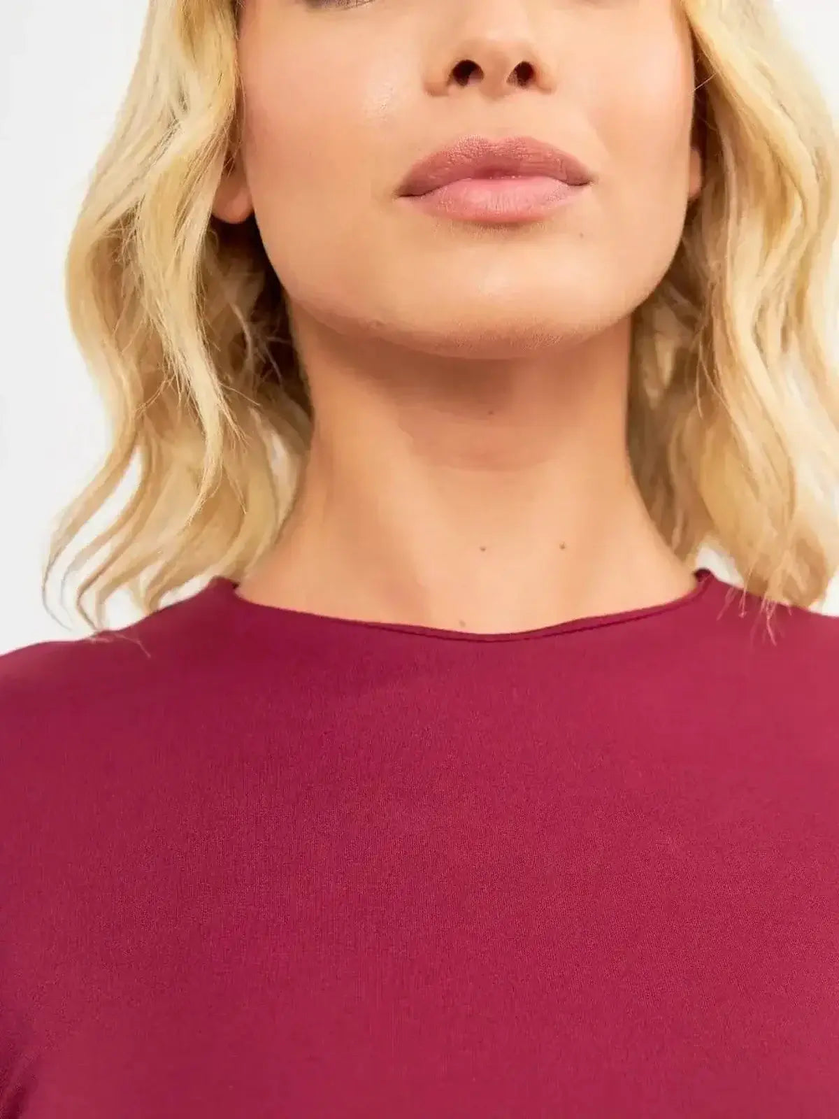 Close-up of a model wearing the Wine Flare Mini dress, showcasing its round neckline and luxurious fabric.